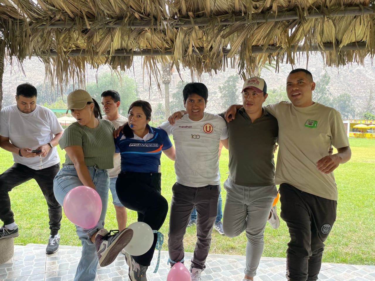 Equipos unidos bajo techo de paja en club campestre